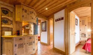 a kitchen with wooden cabinets and an open door at Appartement confortable à Megève | 46m² | Vue sur montagne in Megève +4 photos