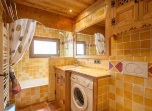 a bathroom with a sink and a washing machine at Appartement confortable à Megève | 46m² | Vue sur montagne in Megève