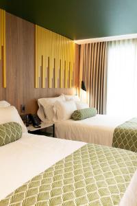 メデジンにあるSloh Hotel & Bar Manila Medellinのベッドが2つと窓があるホテルの部屋