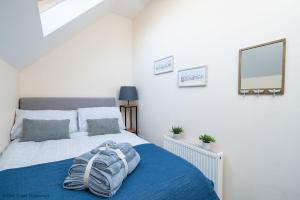 a bedroom with a bed with a blue blanket on it at Dog friendly cottage with hot tub under 350 steps to dunes in Winterton-on-Sea