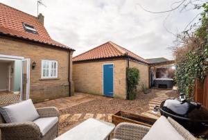 a backyard with a fire pit and a house at Dog friendly cottage with hot tub under 350 steps to dunes in Winterton-on-Sea
