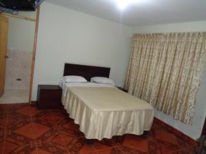 1 dormitorio con cama y ventana en Antares Inn, en Lima