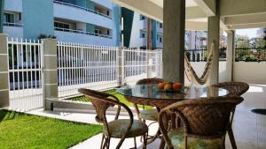 ボンビーニャスにあるResidencial Marcelo Pinheiroのバルコニーにテーブルと椅子が置かれたパティオ