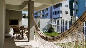 ボンビーニャスにあるResidencial Marcelo Pinheiroのバルコニーにハンモック、テーブル、建物