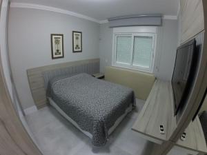 ボンビーニャスにあるResidencial Marcelo Pinheiroのベッドと薄型テレビのある寝室