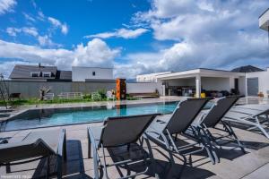 a patio with chairs and a swimming pool at Villa "Colmar" Spa and Free vine test in Raedersheim