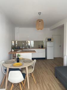 a living room with a table and chairs and a kitchen at Sea La Vie Apartment Porto Santo in Porto Santo