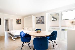 ein Wohnzimmer mit einem Tisch, Stühlen und einem Bett in der Unterkunft Das Solaris Beach Apartment 20 mit Garten, Sauna und hundefreundlicher Ausstattung in Grömitz