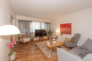 a living room with a couch and a tv at Apartment LA Invest in Rovaniemi