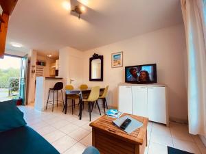 a living room with a couch and a table at Serena Entre mer et forêt in Camiers