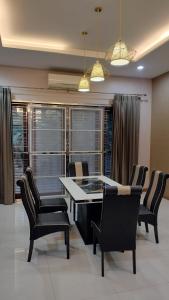 a dining room with a table and chairs and windows at The Horizon Villa Songkhla in Ban Mai +7 photos