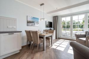 a kitchen and dining room with a table and chairs at Rungholt in Ording