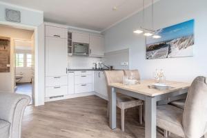 una cucina e una sala da pranzo con tavolo e sedie di Rungholt a Ording Altre 16 foto