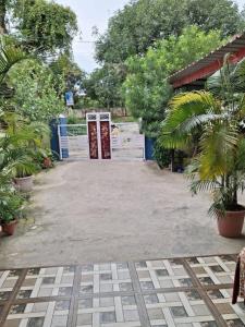 a driveway with two doors in a yard with trees at Kamla Kantam Home Stay in Kota Bāgh