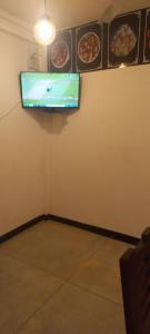 a room with a tv on a wall with pizzas at Wije House in Dickwella
