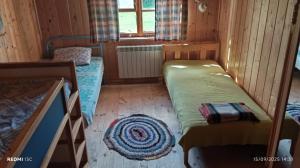 a small room with two beds in a cabin at Stajnia Okliny in Wiżajny
