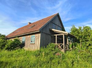 an old black barn with a brown roof at Stajnia Okliny in Wiżajny