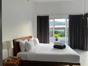 ein Schlafzimmer mit einem Bett, auf dem eine schwarze Tasche liegt in der Unterkunft Tranquil Oasis in Taling Ngam 2-Bedroom Pool Villa in Ban Phang Ka