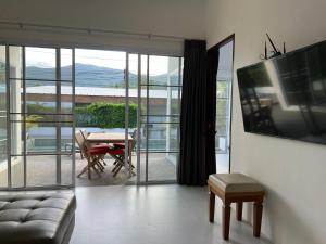 ein Wohnzimmer mit einer Couch und einem Tisch mit einem Fernseher in der Unterkunft Tranquil Oasis in Taling Ngam 2-Bedroom Pool Villa in Ban Phang Ka