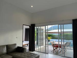 ein Wohnzimmer mit einem Sofa und Blick auf einen Innenhof in der Unterkunft Tranquil Oasis in Taling Ngam 2-Bedroom Pool Villa in Ban Phang Ka