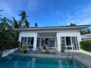 ein weißes Haus mit einem Swimmingpool davor in der Unterkunft Tranquil Oasis in Taling Ngam 2-Bedroom Pool Villa in Ban Phang Ka + 19 Fotos