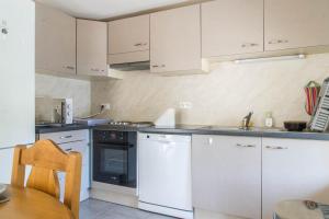 a kitchen with white cabinets and a sink and an oven at Gîte du mazel in Naussac