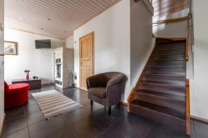 ein Wohnzimmer mit einer Treppe und einem Stuhl in der Unterkunft Karkutahko Villas 1B - Spacious 3BR Villa in Tahko with Private Sauna in Tahkovuori