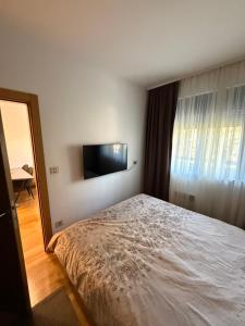 a bedroom with a bed and a flat screen tv at Leo Pine Lux Apartments in Zlatibor