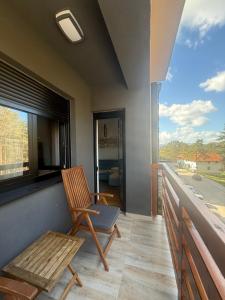 a wooden chair sitting on a balcony with a window at Leo Pine Lux Apartments in Zlatibor