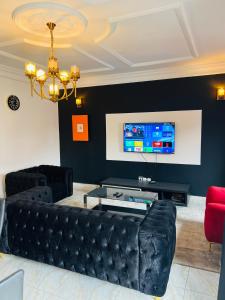 a living room with a couch and a tv at Résidence O-calme in Yaoundé +24 photos