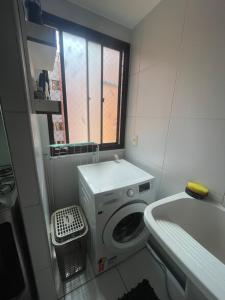 a small bathroom with a washing machine and a sink at Próx a praia in São Luís