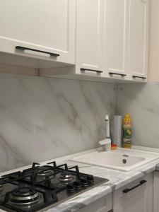 a kitchen with a stove and a sink at Квартира в районе Esentai Mall in Almaty +12 photos