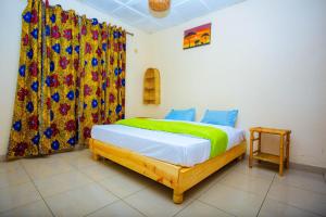 una camera da letto con un letto con una tenda colorata di Vital Corner a Ruhengeri