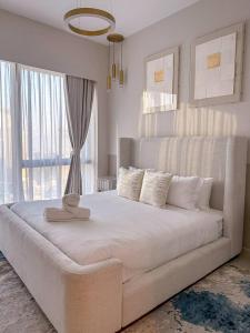 a bedroom with a large white bed with a large window at GRANDE RESIDENCES with a direct Burj Khalifa view and Private Fountain Show at 42nd floor with DXB AIRPORT VIP Shuttle in Dubai