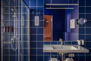 a blue bathroom with a sink and a shower at BYPILLOW Flamant in Barcelona +61 photos