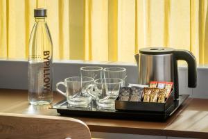 a tray with a coffee maker and glasses and a bottle at BYPILLOW Flamant in Barcelona