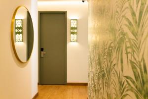 un corridoio con porta verde e specchio di Sloh Hotel & Bar Manila Medellin a Medellín Altre 33 foto