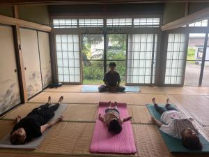 大仙市にある結ライ処 出羽紬yuraidokoro dewatsumugiの部屋でヨガをしている3人のグループ