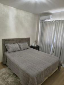 ein Schlafzimmer mit großem Bett und Fenster in der Unterkunft Apartamento aconchegante com ar, secadora e adega in Piratuba + 21 Fotos