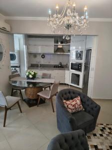 ein Wohnzimmer mit Tisch und Stühlen und einem Kronleuchter in der Unterkunft Apartamento aconchegante com ar, secadora e adega in Piratuba