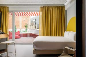 a bedroom with a bed and a large window at BYPILLOW Flamant in Barcelona