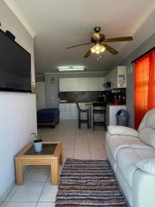 Una sala de estar con un sofá y un ventilador de techo. en Kelpmeeu Self- Catering and Car hire, en Swakopmund 5 fotos más
