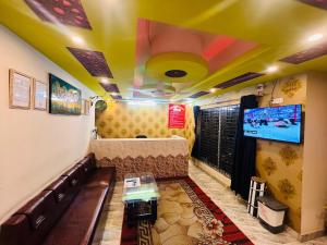 a room with a couch and a tv on the ceiling at Hotel Inn Chittagong in Chittagong