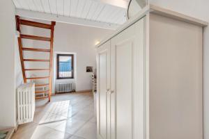 a hallway with white cabinets and a staircase in a house at Casa tua Alla Torre- Lago Di Iseo in Marone
