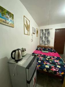 a small bedroom with a bed and a tea kettle at Honu Homestay Siargao in Sampong