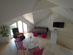 a living room with a table and chairs and a bed at CASABINA Appartement entre Disney et paris in Chelles