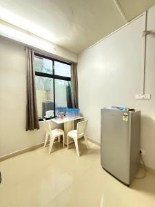 - une cuisine avec une table et un réfrigérateur dans la chambre dans l'établissement LP Homes, à Kohīma