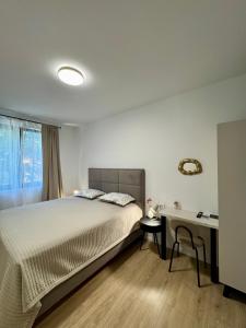 een slaapkamer met een bed en een bureau bij Villa D Cube in Kremena