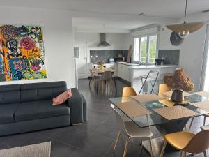 Una sala de estar y una cocina con un sofá y una mesa. en villa Maopi, en Wimereux