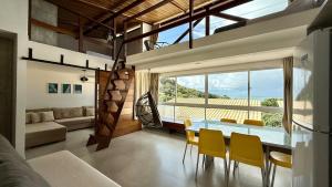 a dining room and living room with a table and chairs at Casa Oxente - 2da praia condominio com piscina in Cayru